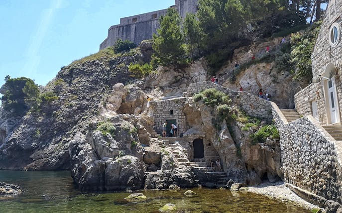 Guests exploring Lovrijenac Fort's rocky path in Dubrovnik, Croatia.