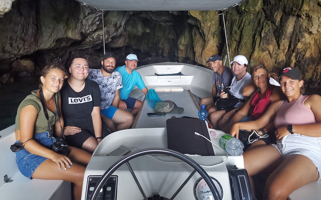 Group on a boat tour inside a sea cave near Ortigia Island.
