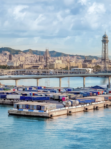 Port of Barcelona with city skyline, featuring Magic Sailing Experience with local captain.