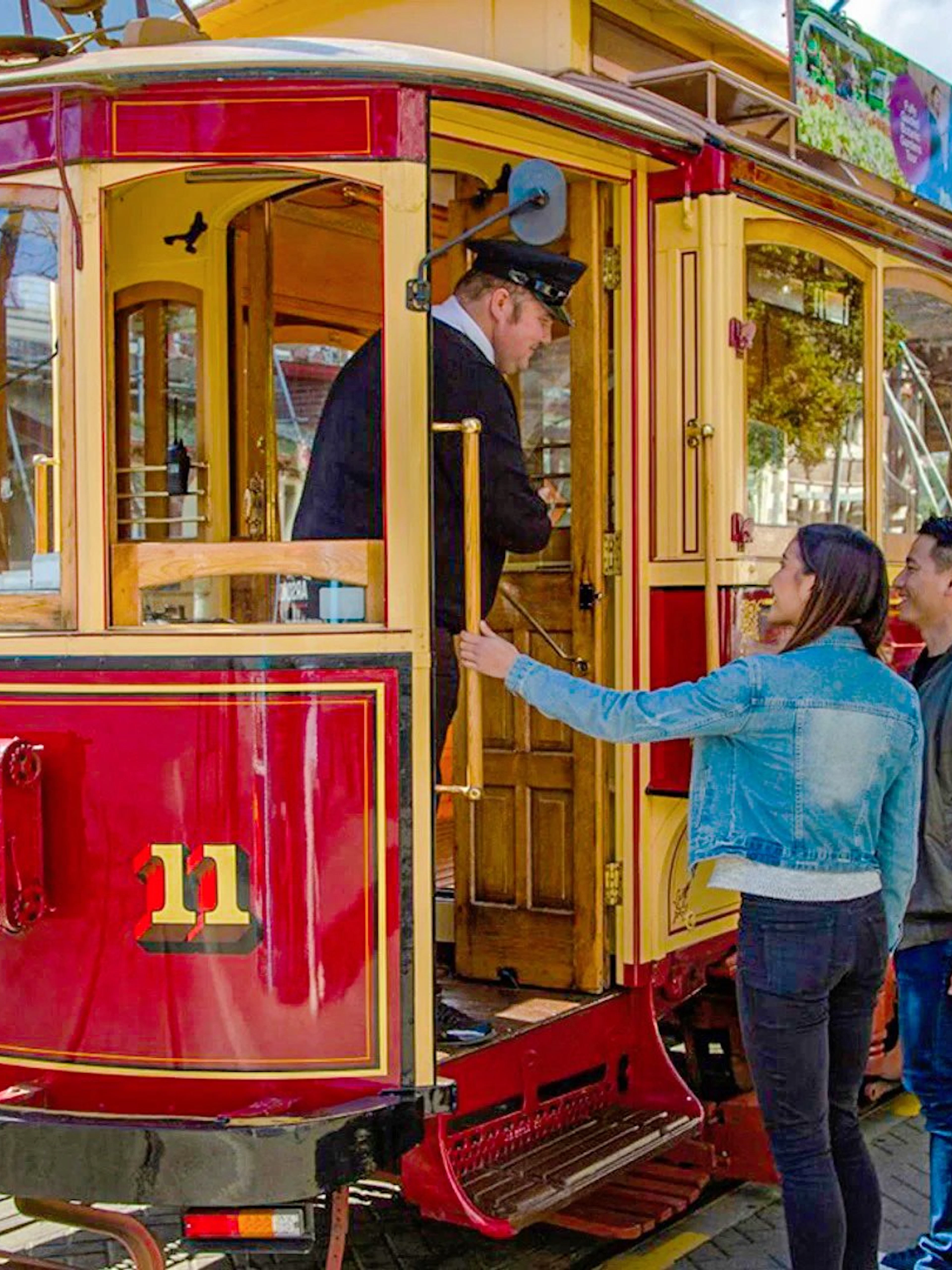 Couple boarding vintage tram in Christchurch city loop.