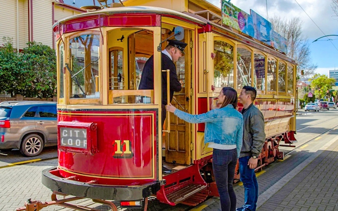 Couple boarding vintage tram in Christchurch city loop.