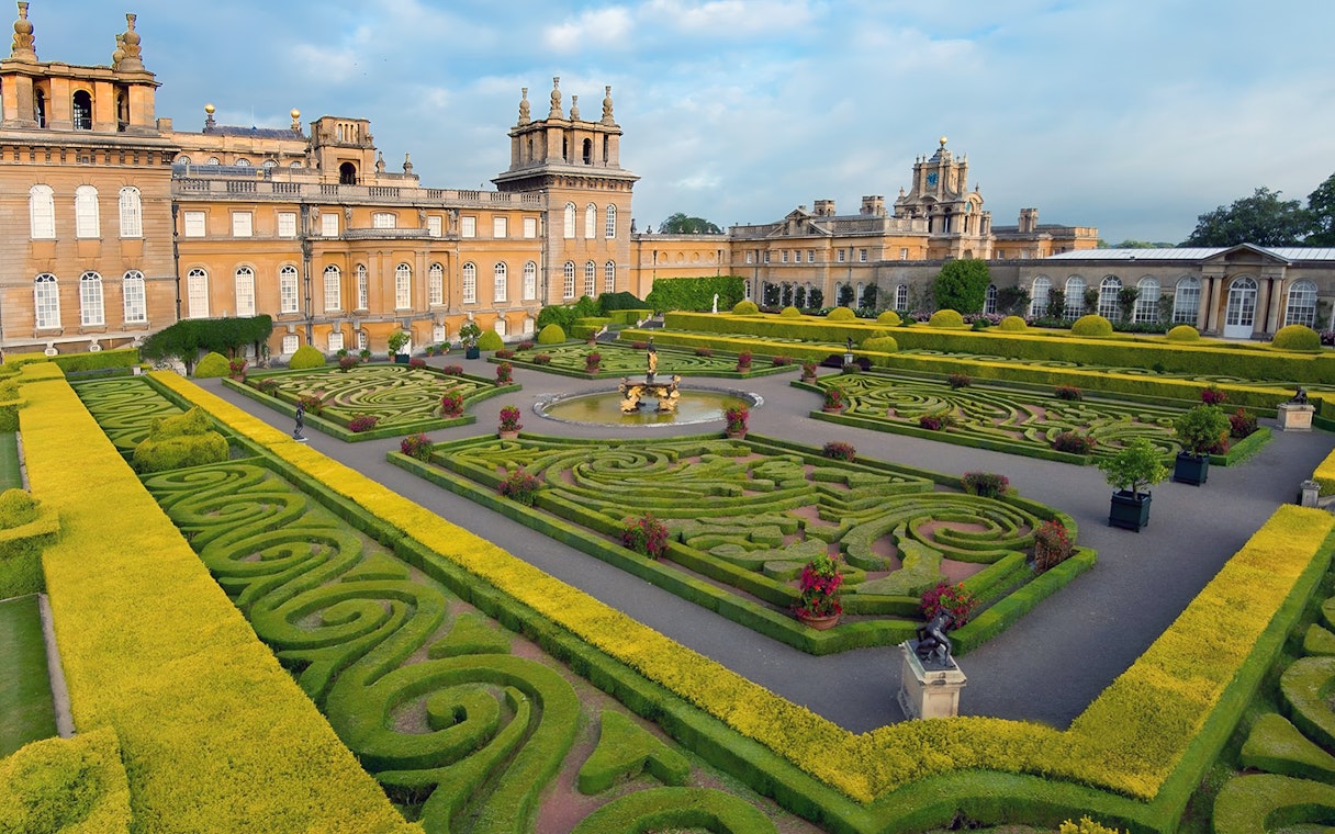 Blenheim Palace gardens with intricate hedges and fountain, part of Downton Abbey Village & The Cotswolds Tour.