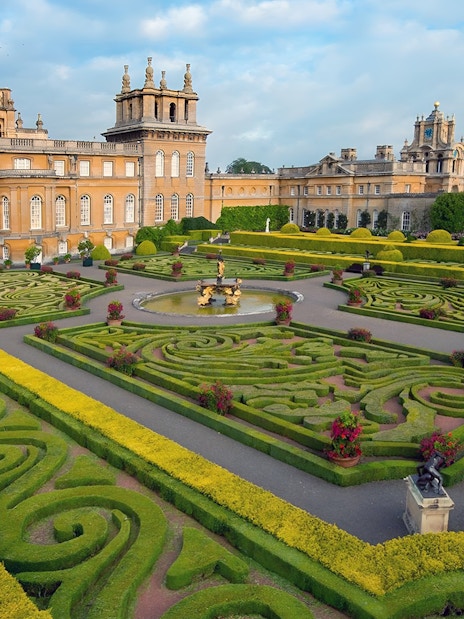 Blenheim Palace gardens with intricate hedges and fountain, part of Downton Abbey Village & The Cotswolds Tour.