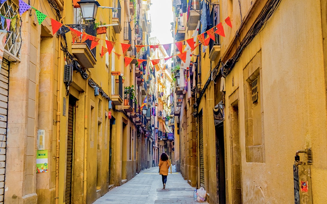 El Born street in Barcelona with colorful flags and historic buildings.