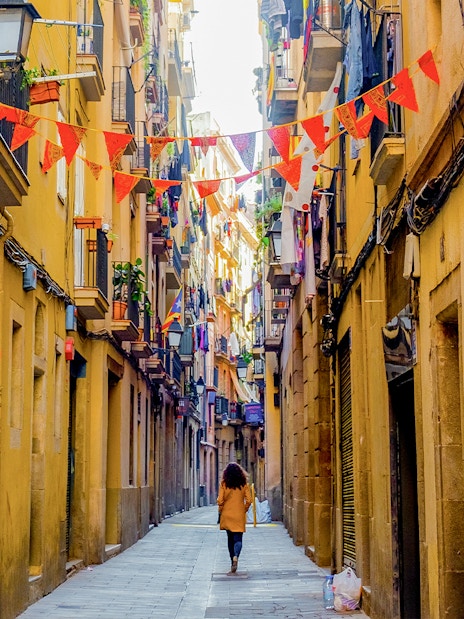 El Born street in Barcelona with colorful flags and historic buildings.