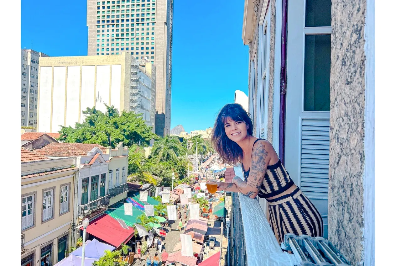 Woman enjoying view from balcony over Rio Scenarium street market, Rio de Janeiro.