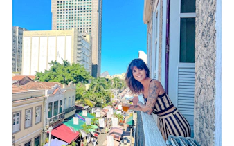 Woman enjoying view from balcony over Rio Scenarium street market, Rio de Janeiro.