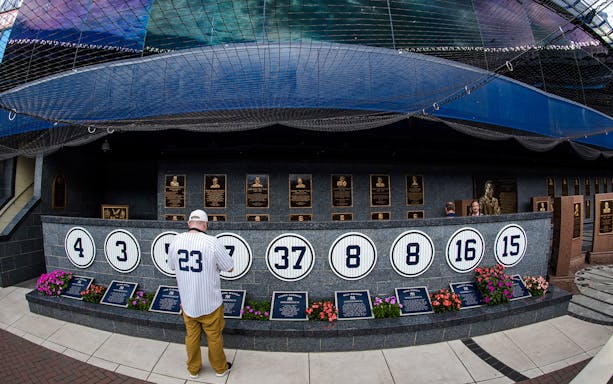 Yankees Monument Park with retired numbers and plaques at Yankee Stadium.