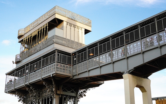 Santa Justa Lift in Lisbon, Portugal, with intricate ironwork against a blue sky.