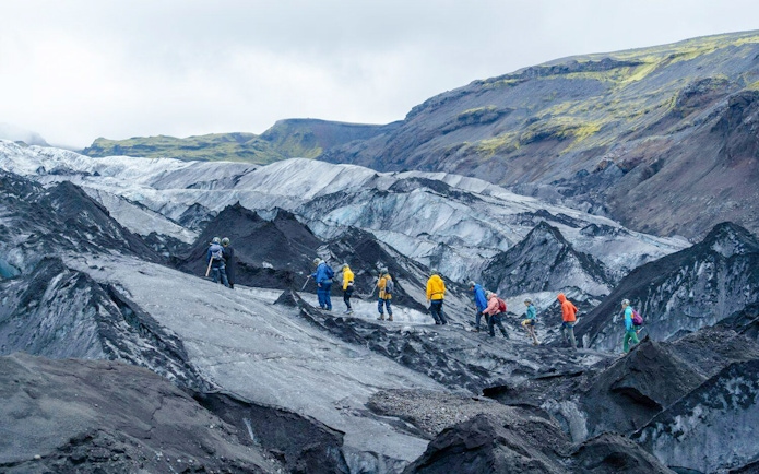 Hikers exploring Sólheimajökull glacier in Iceland.