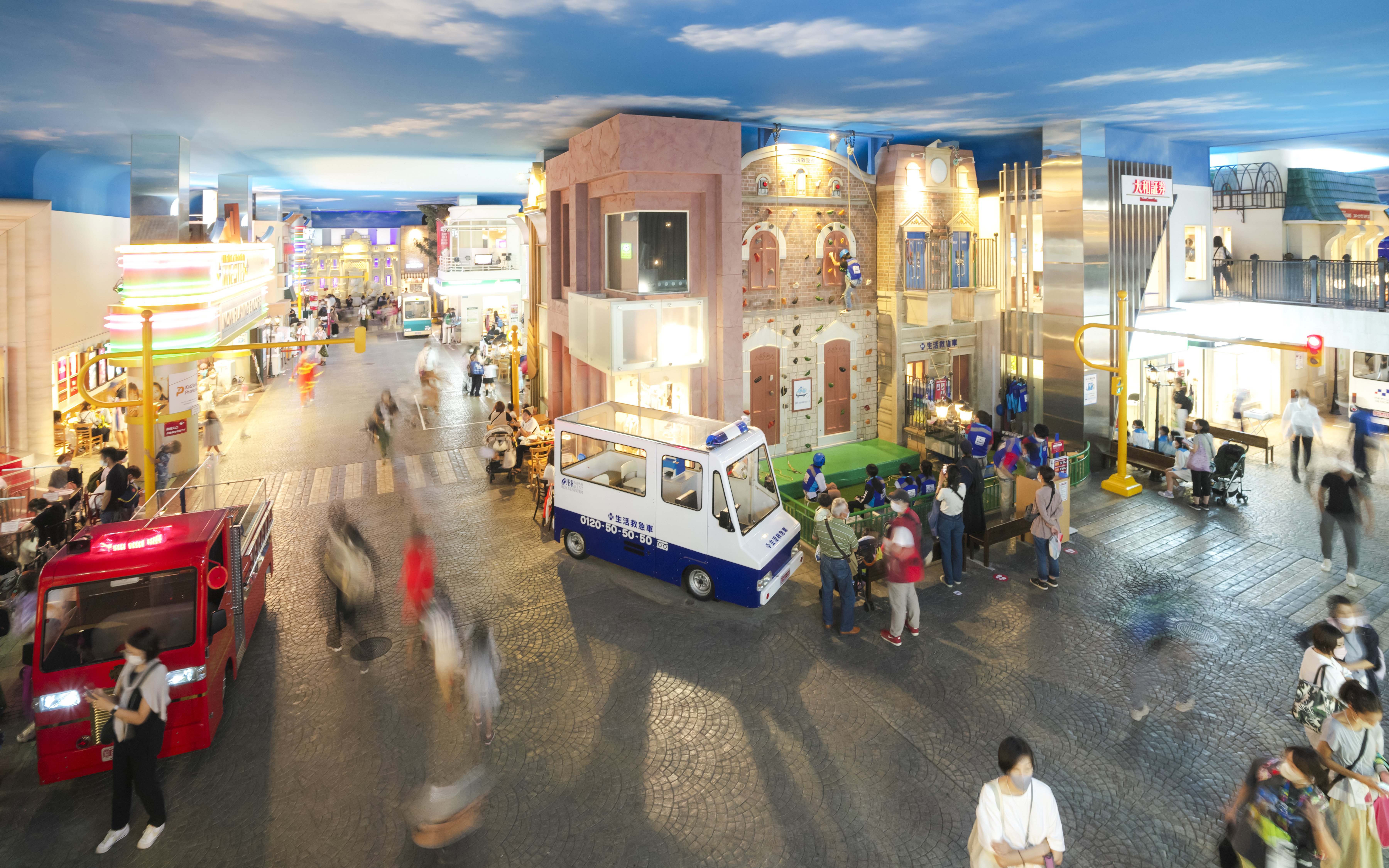 Visitors exploring Kidzania Tokyo with interactive exhibits and mini vehicles.