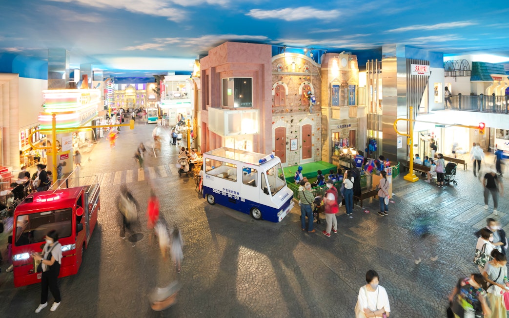 Visitors exploring Kidzania Tokyo with interactive exhibits and mini vehicles.