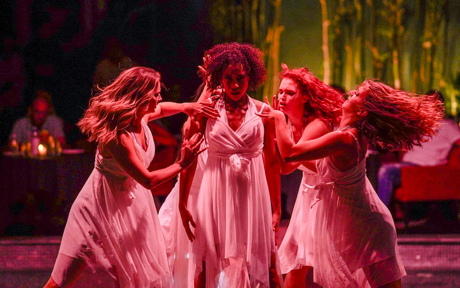 Performers in white dresses dancing at Nouba Restaurant Dinner Show.