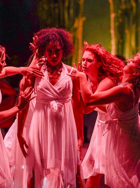 Performers in white dresses dancing at Nouba Restaurant Dinner Show.