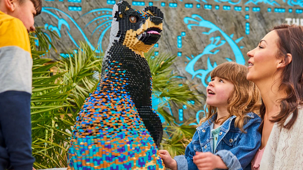 Guests admiring a colorful Lego bear sculpture at Legoland Windsor.