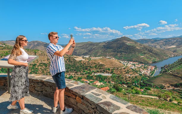 Tourists photographing Douro Valley landscape, Portugal.