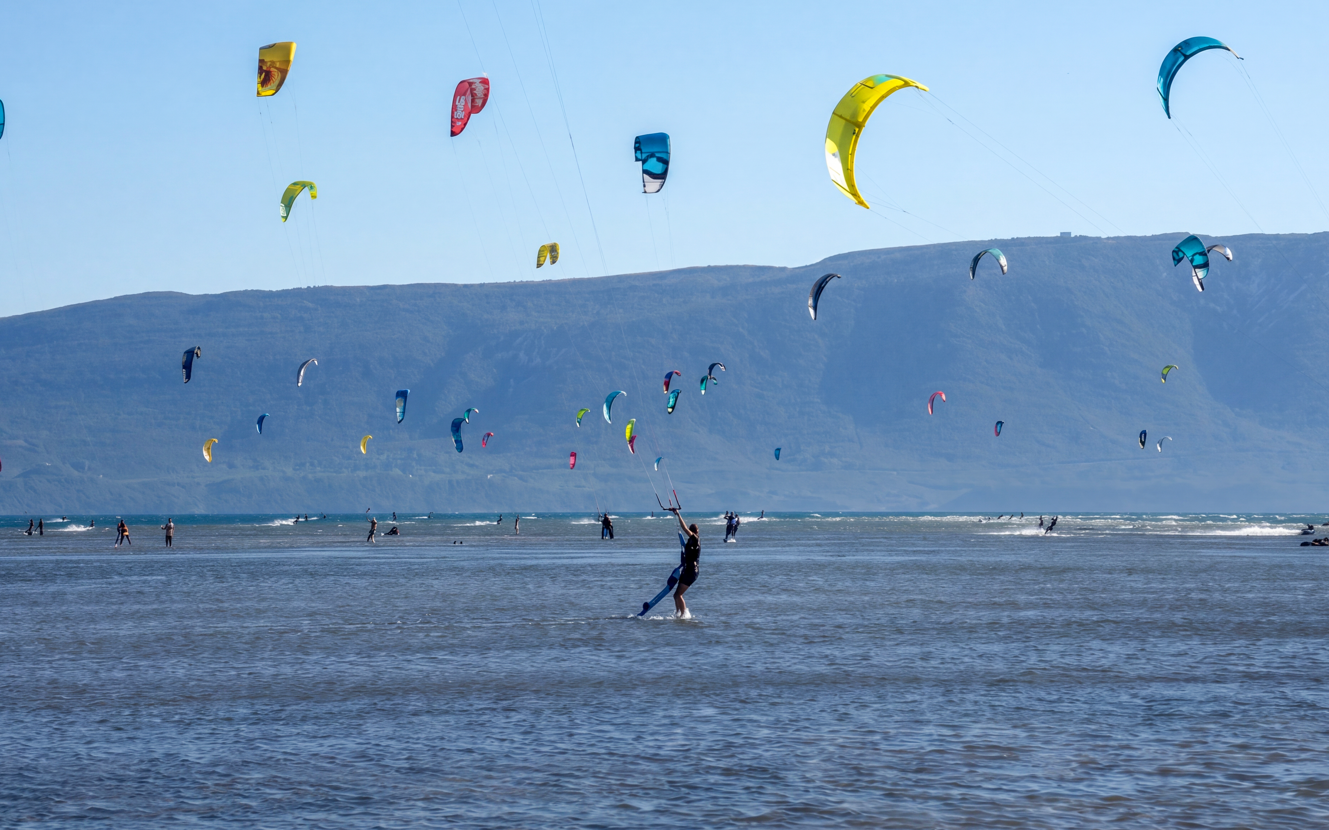 Kiteboarders on the water with colorful kites at Delta Neretva, Croatia.