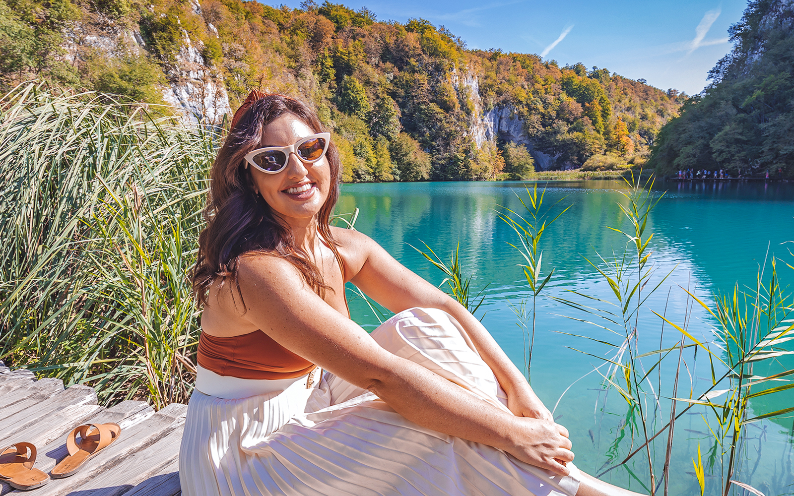 Visitor relaxing by the turquoise waters of Plitvice Lakes National Park, Croatia.