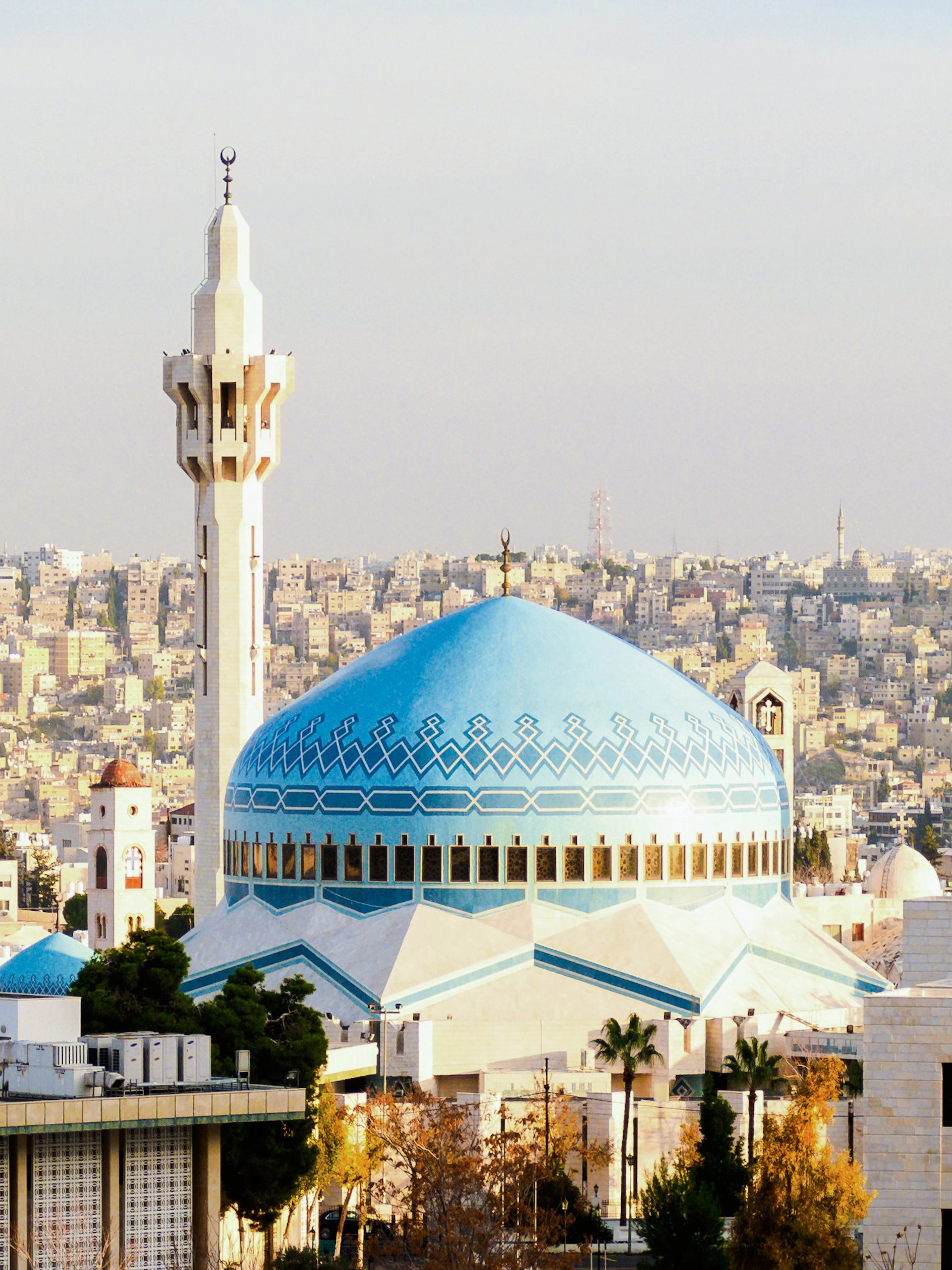 King Abdullah I Mosque with blue dome and minarets in Amman, Jordan cityscape.