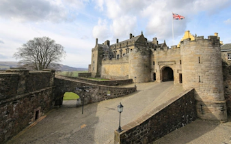 Stirling Castle entrance with stone walls and Union Jack flag flying.