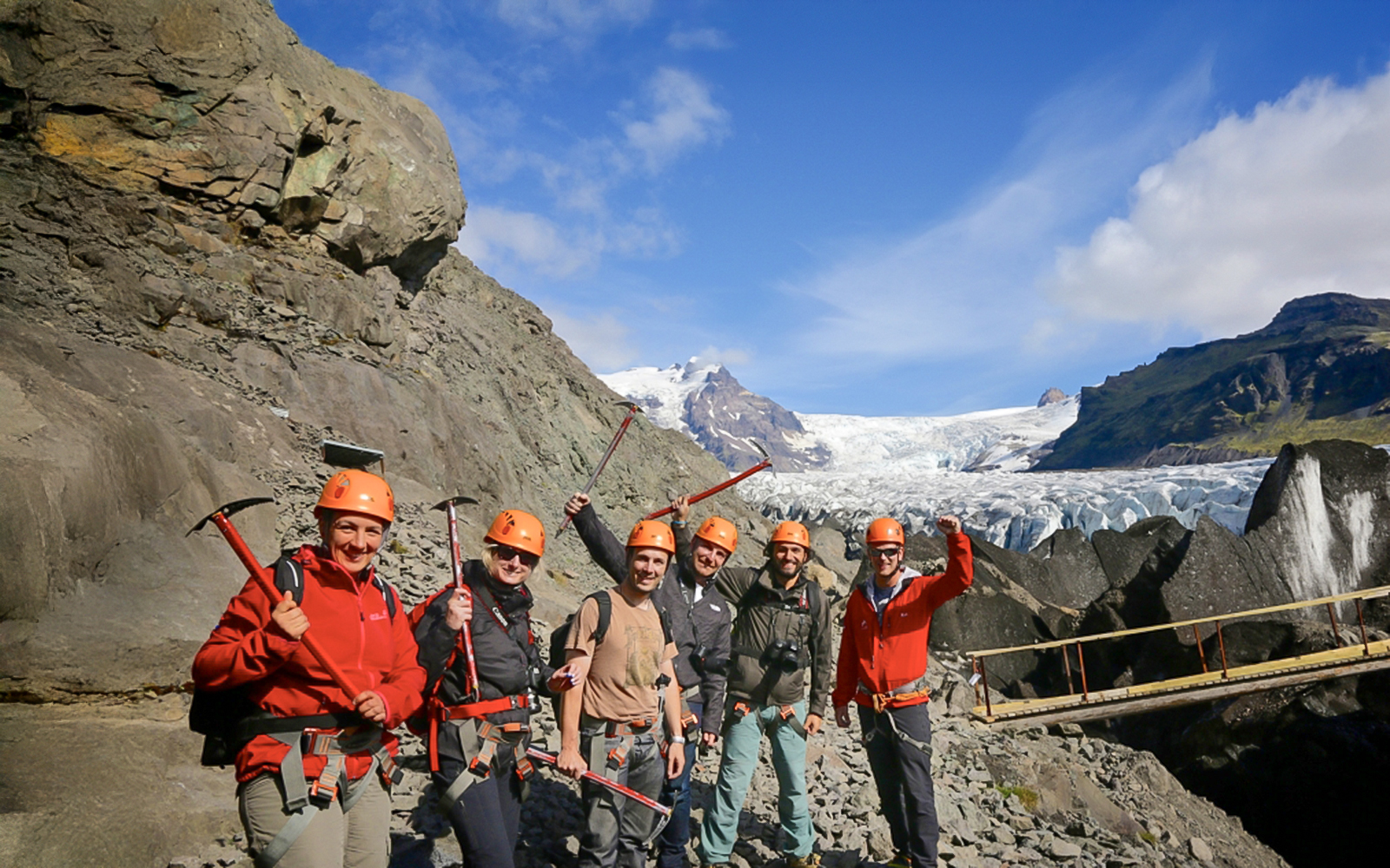 Guests with ice axes on a glacier hike in Skaftafell, Iceland, with a glacier in the background.