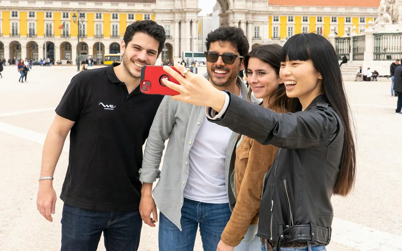 Tourists taking a selfie at Praça do Comércio during Lisbon walking tour.