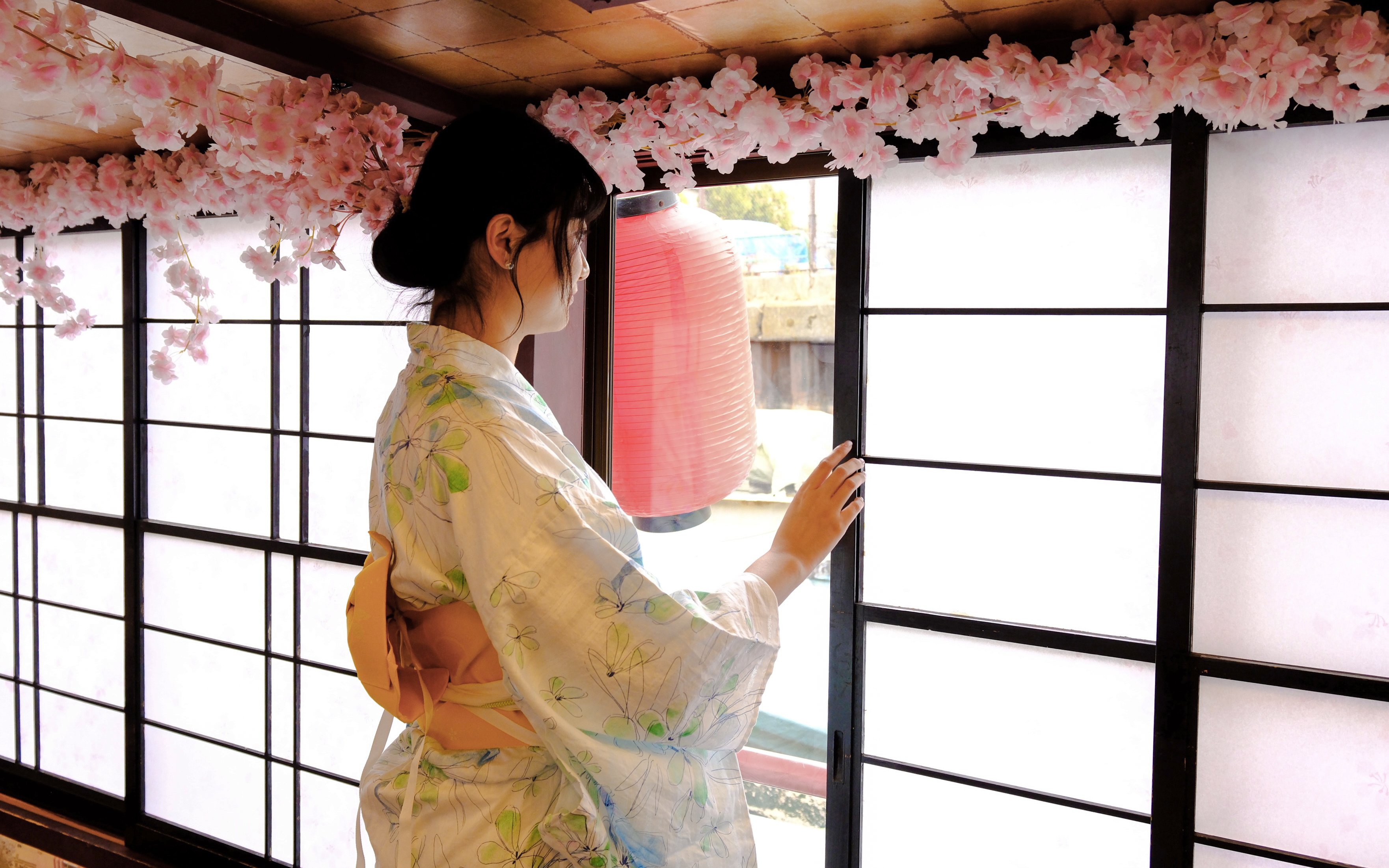 Person in kimono at Tokyo tea ceremony with cherry blossoms and lantern.