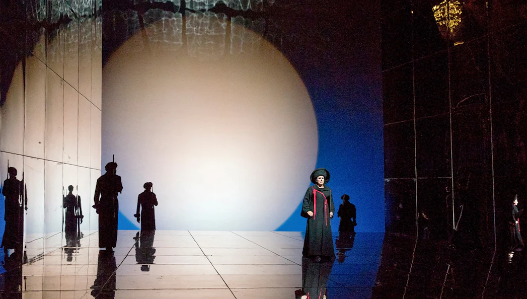 Opera scene from "Die Frau Ohne Schatten" with performers on a reflective stage.