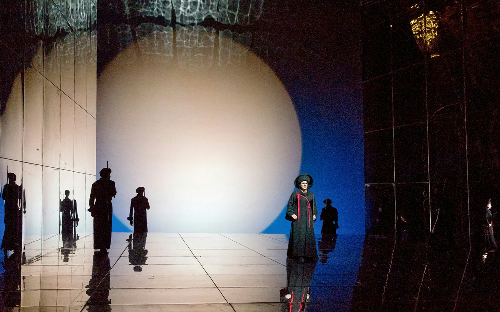 Opera scene from "Die Frau Ohne Schatten" with performers on a reflective stage.