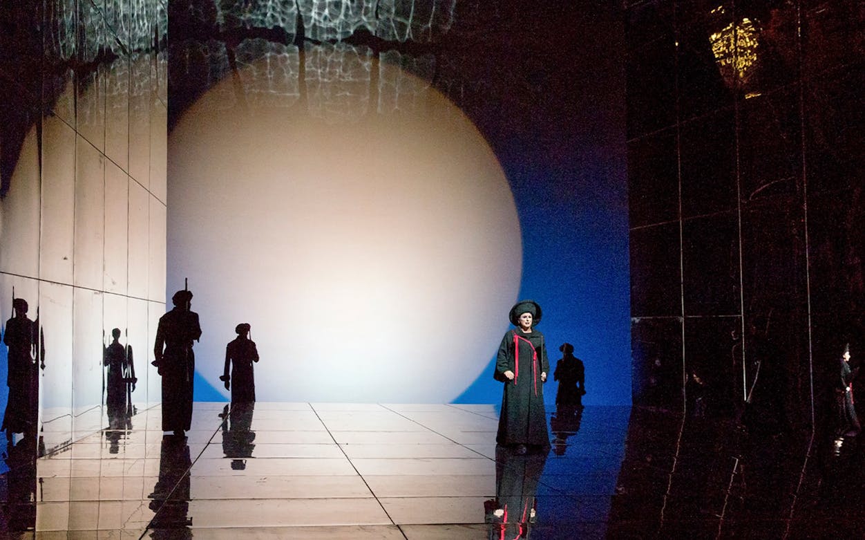 Opera scene from "Die Frau Ohne Schatten" with performers on a reflective stage.