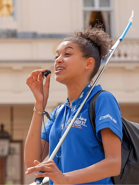 Tour guide speaking outside Buckingham Palace during a guided tour of the State Rooms.