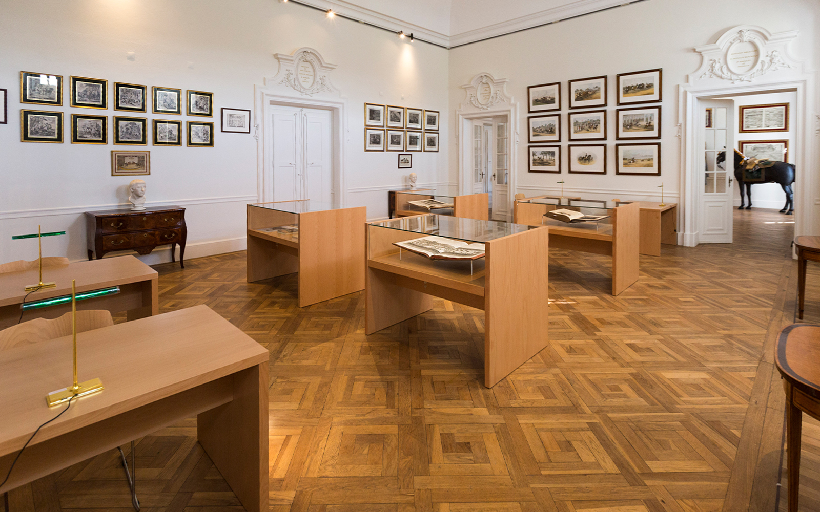 National Palace of Queluz Library with display tables and framed artwork.