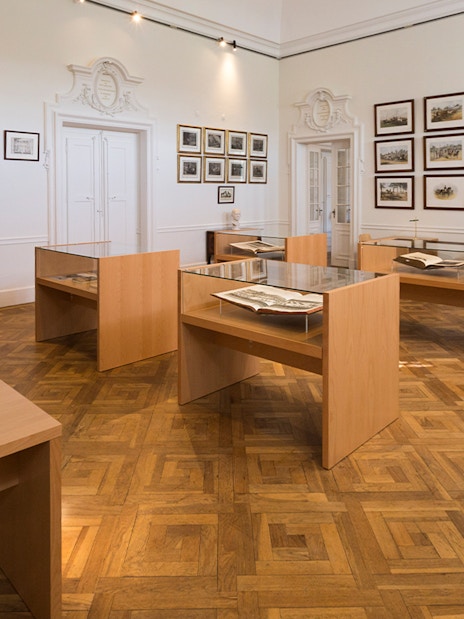 National Palace of Queluz Library with display tables and framed artwork.