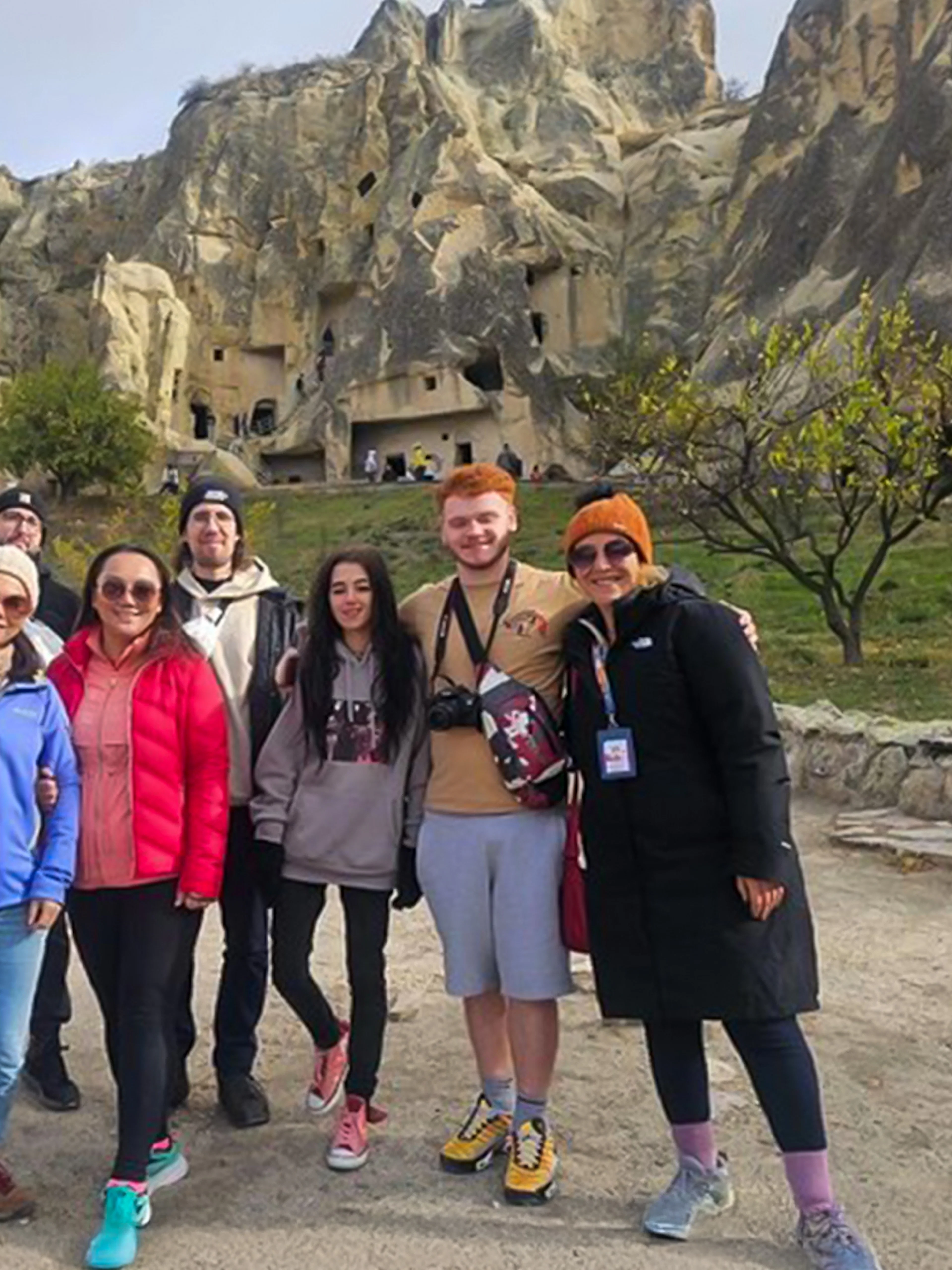 Guests exploring Uchisar Castle in Cappadocia with rock formations in the background.