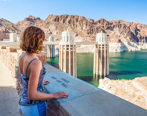 Visitor overlooking Hoover Dam reservoir during exploration tour.