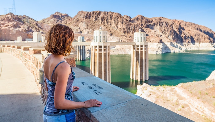 Visitor overlooking Hoover Dam reservoir during exploration tour.