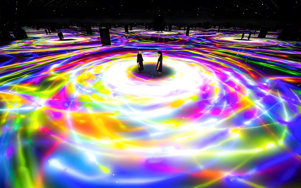 Visitors immersed in colorful digital art installation at teamLab Planets TOKYO.