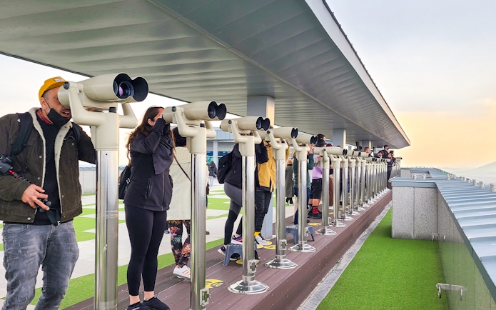 Tourists using binoculars at Dorasan Observatory in South Korea.