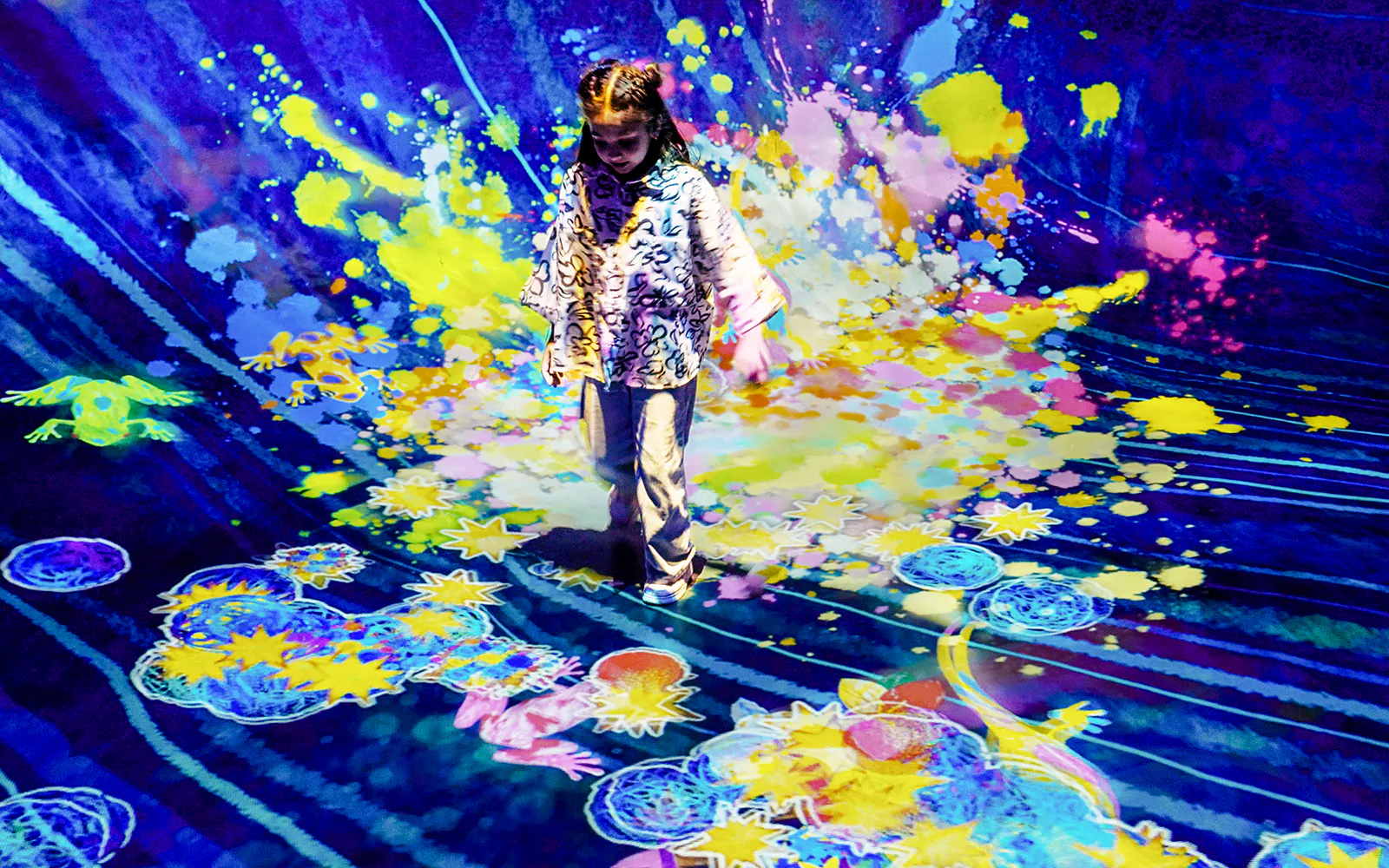 A visitor walks through a colourful interactive installation at teamLab Phenomena Abu Dhabi.
