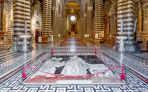 Siena Cathedral interior with intricate marble floor design and striped columns.
