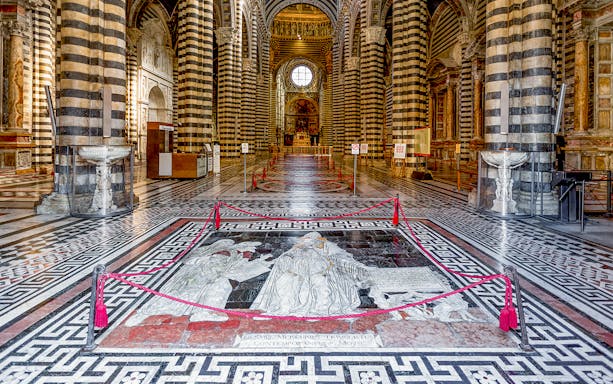 Siena Cathedral interior with intricate marble floor design and striped columns.