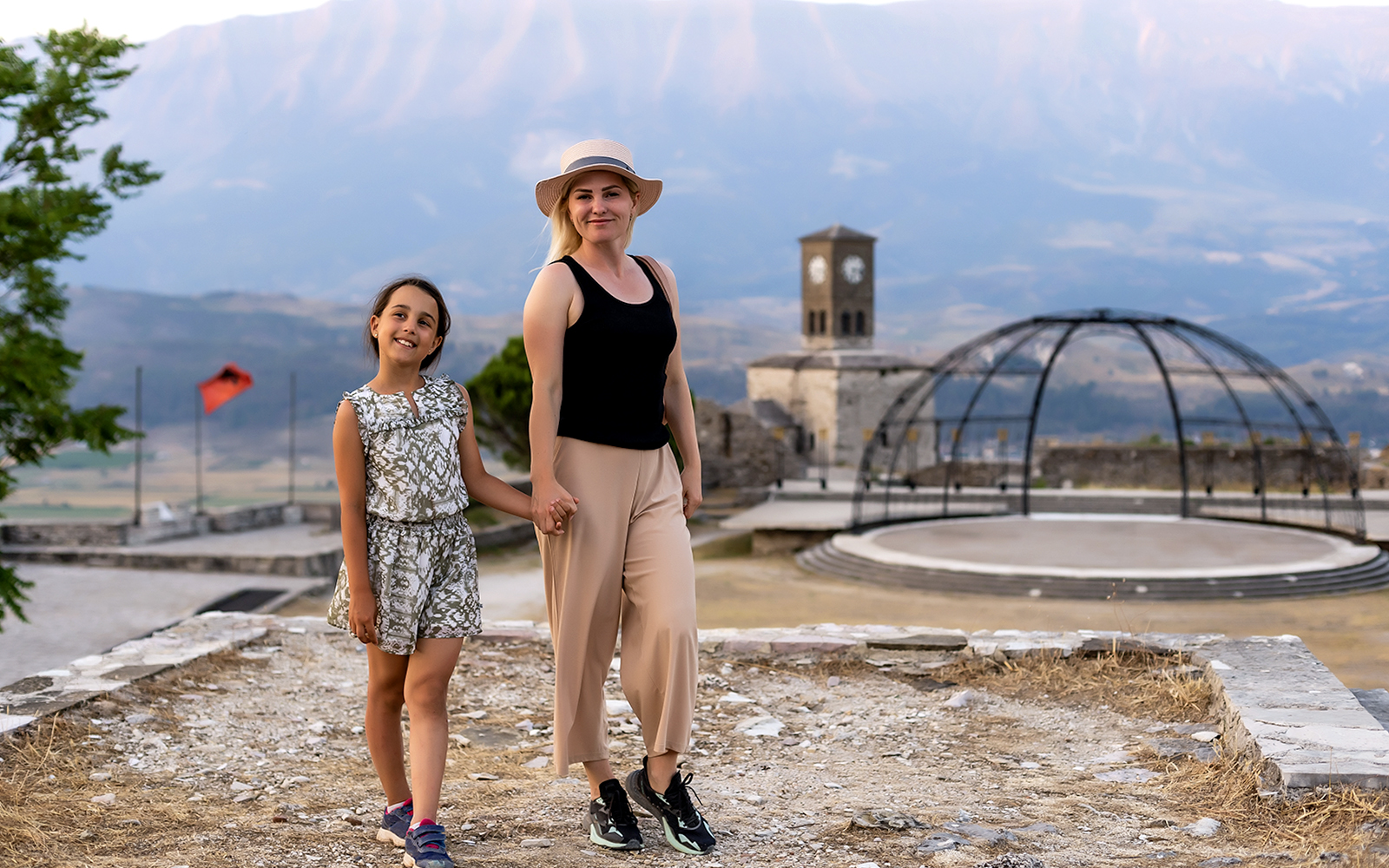 Guests exploring Gjirokaster Castle with clock tower in the background.