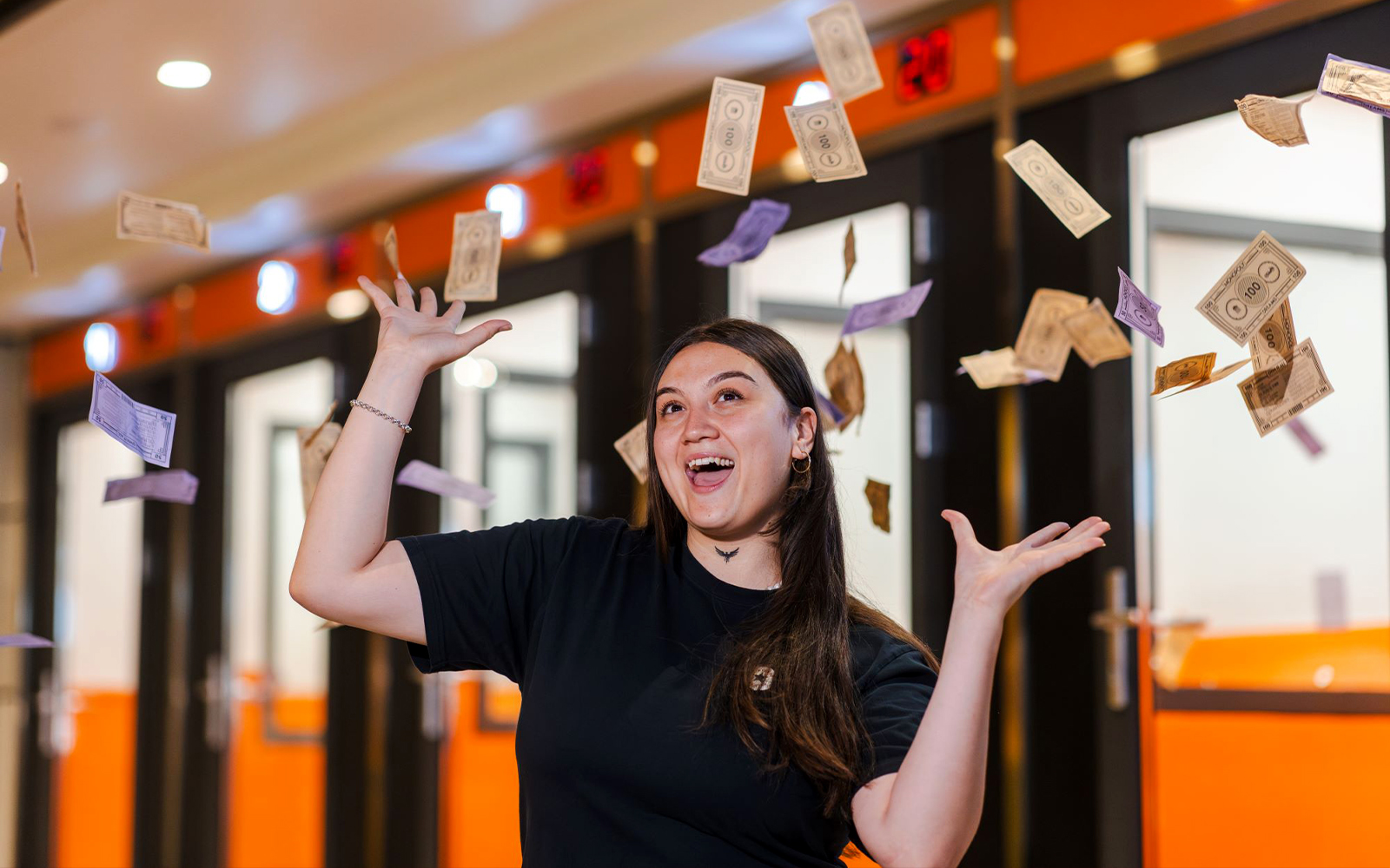 Person enjoying Monopoly Dreams Melbourne with play money in the air.