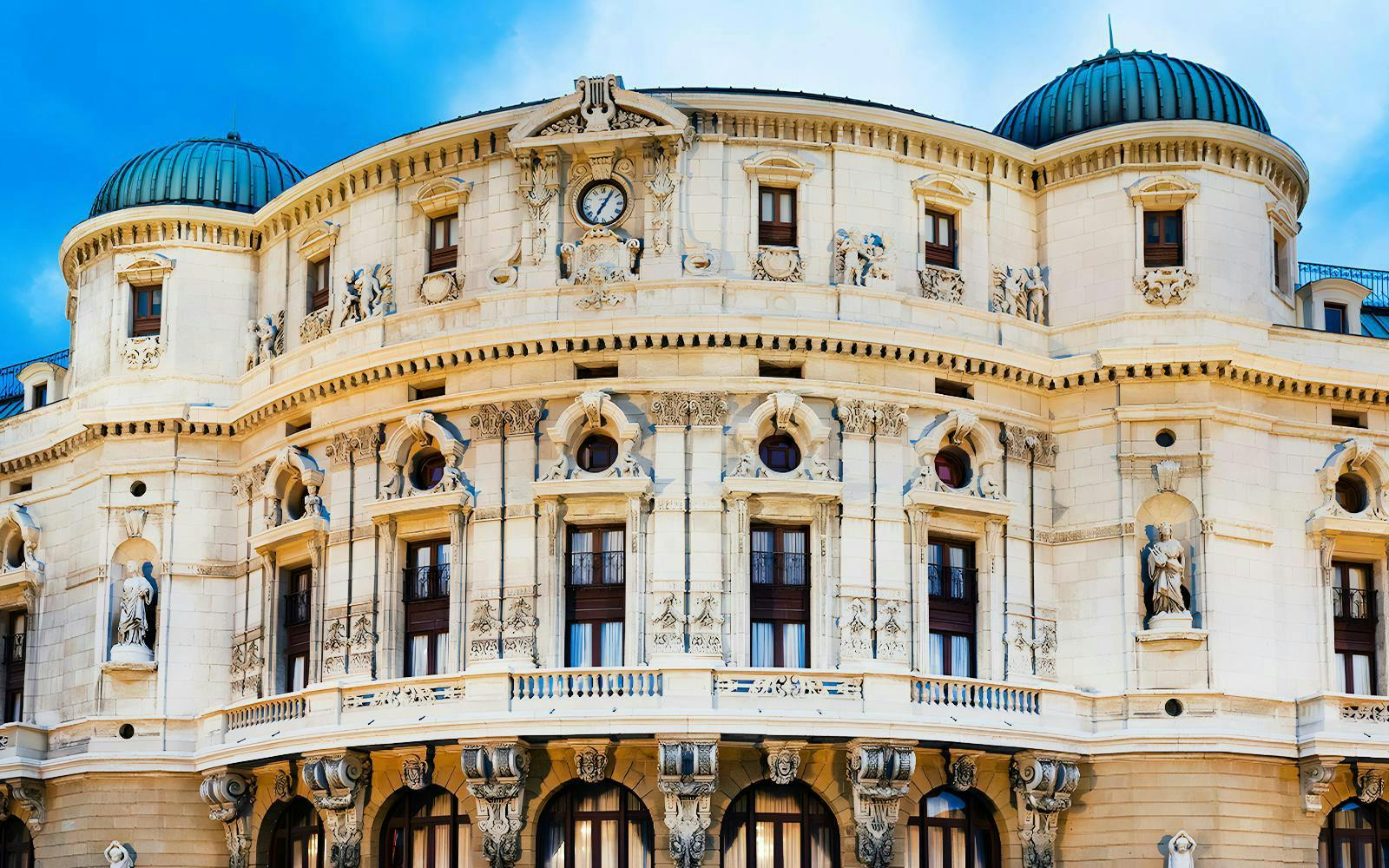 Teatro Arriaga facade with ornate sculptures and clock in Bilbao, Spain.