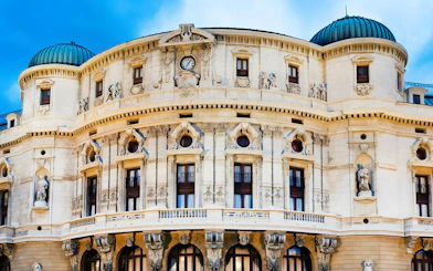 Teatro Arriaga facade with ornate sculptures and clock in Bilbao, Spain.