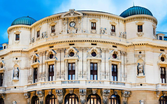 Teatro Arriaga facade with ornate sculptures and clock in Bilbao, Spain.