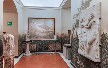 National Archaeological Museum Naples interior with classical sculptures and fresco.