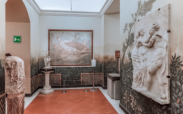 National Archaeological Museum Naples interior with classical sculptures and fresco.