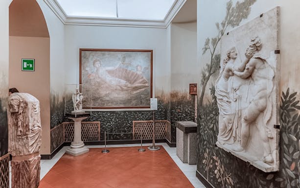 National Archaeological Museum Naples interior with classical sculptures and fresco.