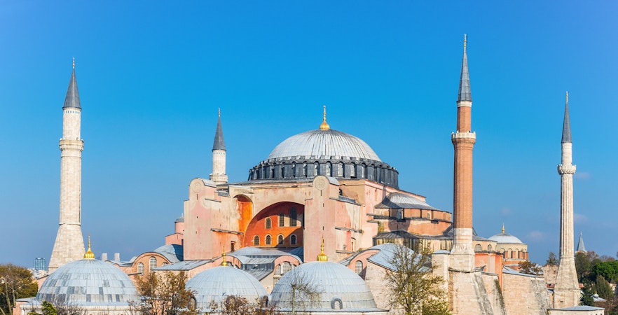 Hagia Sophia with minarets under clear blue sky in Istanbul.